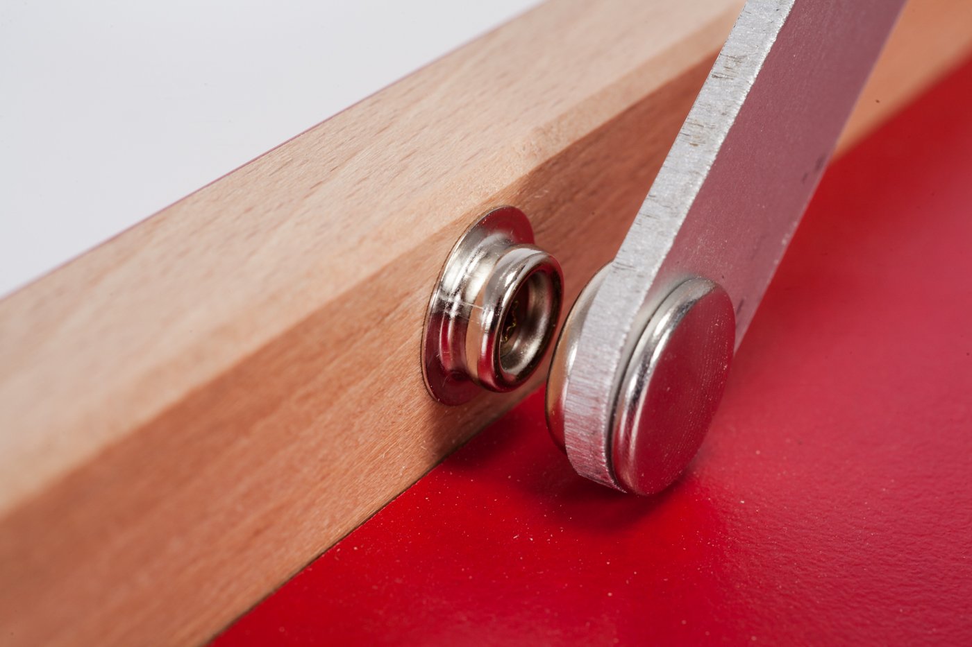 Closeup of metal push button inside the  wooden frame of Mini ping-pong table red "The hot chili"